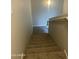 Carpeted stairway leading to a lower level, featuring a white handrail and neutral colored walls at 1920 E Bell Rd # 1188, Phoenix, AZ 85022