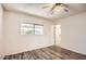 Bedroom with wood-look flooring, a ceiling fan, and view of the back yard from the bright window at 2333 E Larkspur Dr, Phoenix, AZ 85022