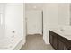Bright bathroom featuring double sinks, tile flooring, and bathtub at 24612 W Grenadine Rd, Buckeye, AZ 85326