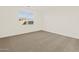 Bright bedroom featuring neutral carpet, white walls, and a large window at 24612 W Grenadine Rd, Buckeye, AZ 85326