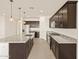 Open-concept kitchen with dark wood cabinets, granite countertops, a center island, and stainless steel appliances at 24612 W Grenadine Rd, Buckeye, AZ 85326
