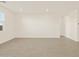 Expansive living room featuring tile flooring, recessed lighting, and bright, neutral walls at 24612 W Grenadine Rd, Buckeye, AZ 85326