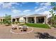 Spacious backyard with artificial grass, desert landscaping, and a cozy fire pit at 26947 W Adam Ave, Buckeye, AZ 85396