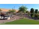 Picturesque backyard featuring a fire pit, artificial turf, decorative gravel, and mature landscaping at 26947 W Adam Ave, Buckeye, AZ 85396