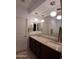 Bathroom featuring dual sinks, granite countertops, modern light fixtures, and a large vanity mirror at 26947 W Adam Ave, Buckeye, AZ 85396