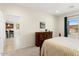 Bright bedroom with dresser, connecting door to bathroom, and outdoor views from the window at 26947 W Adam Ave, Buckeye, AZ 85396