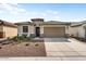 Well-maintained single-story home featuring desert landscaping, a two-car garage, and a welcoming entrance at 26947 W Adam Ave, Buckeye, AZ 85396