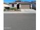 Single-story home featuring a two car garage and desert landscaping at 26947 W Adam Ave, Buckeye, AZ 85396