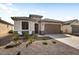Inviting single-story home showcasing desert landscaping, a two-car garage, and a cozy seating area at 26947 W Adam Ave, Buckeye, AZ 85396