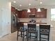 Well-equipped kitchen featuring dark wood cabinets, stainless steel appliances, and a center island with bar stools at 26947 W Adam Ave, Buckeye, AZ 85396