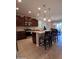 Spacious kitchen with dark cabinets, an island with seating, and stainless steel appliances at 26947 W Adam Ave, Buckeye, AZ 85396