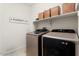 Functional laundry room with modern appliances, a shelf, and stylish decor at 26947 W Adam Ave, Buckeye, AZ 85396