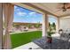 Covered patio overlooking a yard, featuring a comfortable seating area and outdoor dining set at 26947 W Adam Ave, Buckeye, AZ 85396