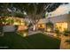 Expansive backyard showcasing a stone waterfall feature, manicured lawn, and mature trees at 3140 E Claremont Ave, Phoenix, AZ 85016