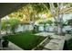 Landscaped backyard featuring a manicured lawn, mature trees, and outdoor living space at 3140 E Claremont Ave, Phoenix, AZ 85016