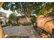 Beautiful backyard featuring a stone waterfall, lush greenery, and travertine pavers at dusk at 3140 E Claremont Ave, Phoenix, AZ 85016