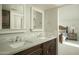 Bathroom with double sink vanity, granite countertop, dark wood cabinets, and connecting bedroom view at 3140 E Claremont Ave, Phoenix, AZ 85016