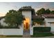 Inviting front entrance with mature trees and a warm light shining through the front door at 3140 E Claremont Ave, Phoenix, AZ 85016