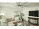 Bright living room features a large sectional sofa, modern ceiling fan, and backyard view at 3140 E Claremont Ave, Phoenix, AZ 85016