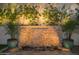 Illuminated stone waterfall with potted palms and flowering vines in a serene backyard setting at 3140 E Claremont Ave, Phoenix, AZ 85016