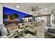 Expansive covered patio with ceiling fans overlooks a sparkling pool and well-manicured backyard with exterior seating at 3401 N 34Th Pl, Phoenix, AZ 85018