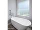 Bright bathroom showcasing an inviting standalone soaking tub beneath a large window at 3401 N 34Th Pl, Phoenix, AZ 85018