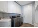 Well-lit laundry room featuring modern washer/dryer units, ample cabinetry, and a sink for added convenience at 3401 N 34Th Pl, Phoenix, AZ 85018