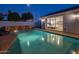 Serene pool area at twilight, featuring a brick waterfall and easy access to the home's interior, offering a tranquil retreat at 3401 N 34Th Pl, Phoenix, AZ 85018