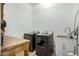 Well-lit laundry room includes washer, dryer, utility sink, and rustic-style wooden folding table at 3485 E Silo Dr, Gilbert, AZ 85296