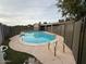 Backyard pool with safety fence, surrounded by a concrete patio and small grassy areas at 3739 W Mission Ln, Phoenix, AZ 85051