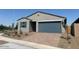 Single-story home featuring a two-car garage and desert landscaping with flowering bushes at 3822 S 87Th Dr, Tolleson, AZ 85353