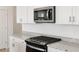 Modern kitchen with stainless steel microwave and black cooktop with light granite countertops at 3822 S 87Th Dr, Tolleson, AZ 85353