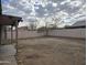 Large, empty backyard with a block wall and covered patio at 4405 W Park St, Laveen, AZ 85339