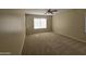 Expansive bedroom featuring neutral carpet, a ceiling fan and a large window overlooking the front yard at 4405 W Park St, Laveen, AZ 85339