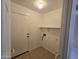 Clean and functional laundry room with tiled floors and essential hookups and shelving at 4405 W Park St, Laveen, AZ 85339