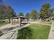 Community park featuring a covered pavilion, picnic benches, mature shade trees, and playground equipment at 4405 W Park St, Laveen, AZ 85339