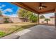 Large grassy backyard featuring a covered patio and desert landscaping at 5108 N 191St Dr, Litchfield Park, AZ 85340