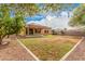 Backyard featuring desert landscaping, mature trees, and covered patio at 5108 N 191St Dr, Litchfield Park, AZ 85340