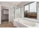 Bright bathroom with a glass shower, soaking tub, and a large window at 5108 N 191St Dr, Litchfield Park, AZ 85340