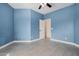 Bedroom featuring tile floors, blue walls, and a door at 5108 N 191St Dr, Litchfield Park, AZ 85340