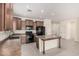 Well-appointed kitchen with dark wood cabinets, black appliances, an island, and tiled floors at 5108 N 191St Dr, Litchfield Park, AZ 85340