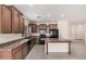 Well-lit kitchen featuring dark cabinets, black appliances, and a functional center island at 5108 N 191St Dr, Litchfield Park, AZ 85340