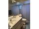 Bathroom featuring a spacious vanity and a bathtub with a shower behind a white curtain at 518 W Beverly Ln, Phoenix, AZ 85023