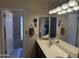 Bathroom featuring a double sink vanity, a large mirror, and a glass block shower at 518 W Beverly Ln, Phoenix, AZ 85023