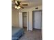 Cozy bedroom with neutral carpet, ceiling fan, closet, and standard door visible with a partial view of a bed at 518 W Beverly Ln, Phoenix, AZ 85023