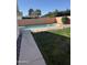 Backyard pool with lush green grass, a brick-lined edge, and a block fence for privacy at 518 W Beverly Ln, Phoenix, AZ 85023