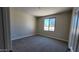 Comfortable bedroom with neutral carpet and a well-lit window showing neighborhood views at 5440 W Snowbird Dr, Eloy, AZ 85131