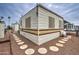 Exterior view of a mobile home with a stone yard and a patio with chairs at 7750 E Broadway Rd # 225, Mesa, AZ 85208