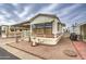 Front exterior of a mobile home with awnings, a fountain, and a stone yard at 7750 E Broadway Rd # 225, Mesa, AZ 85208
