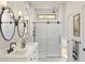 Elegant bathroom with double vanity, modern lighting, and a glass-enclosed shower at 7976 W Griswold Rd, Peoria, AZ 85345